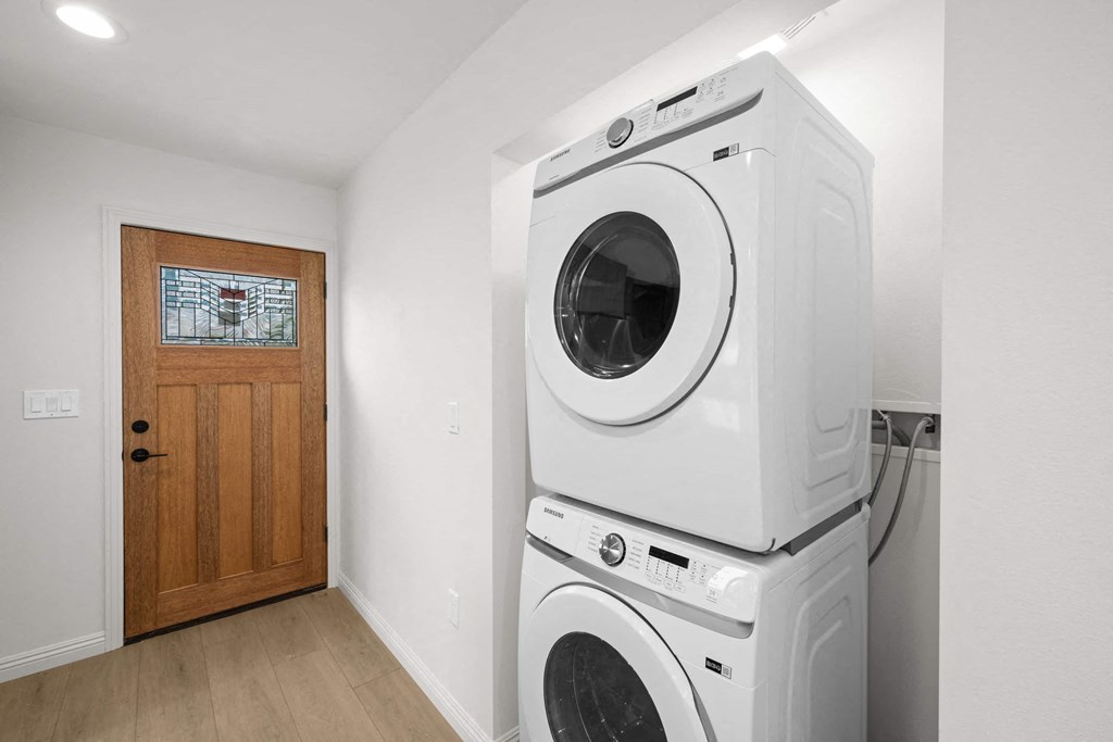 a washer and dryer in a laundry room with a wooden door