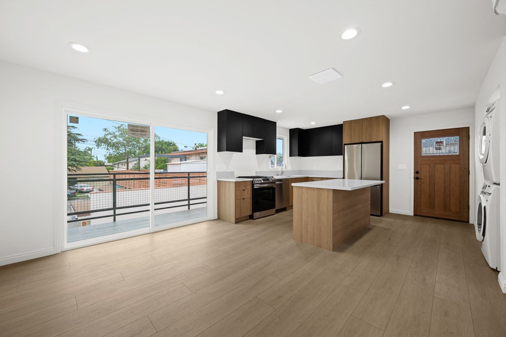 a kitchen with a large window and a door to a balcony