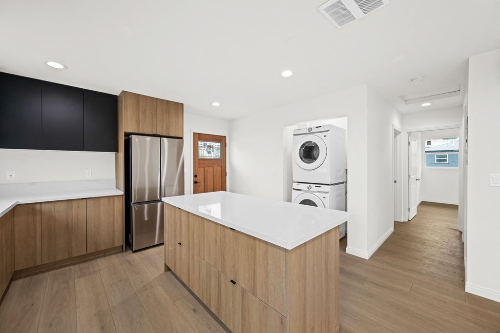 a kitchen with a counter top and a washer and dryer in a house