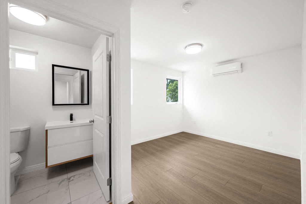 a white bathroom with a toilet and a sink and a mirror