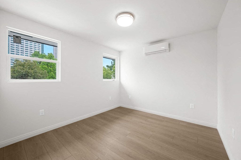 an empty room with white walls and a window