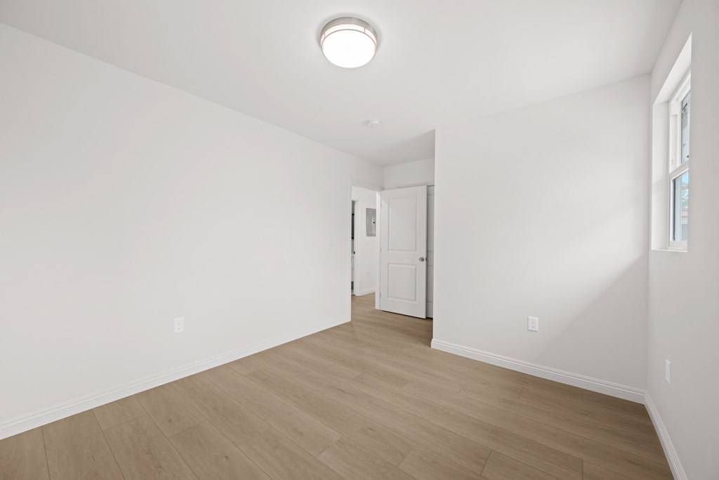 a living room with white walls and a wooden floor