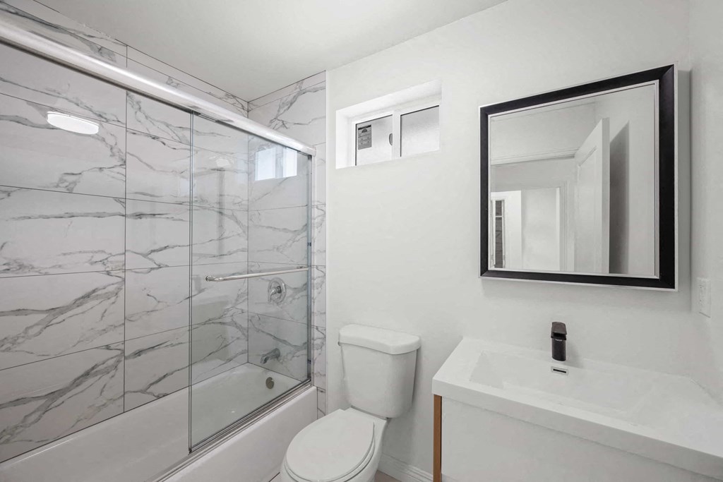 a bathroom with a shower and a sink and a toilet