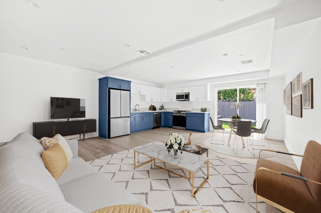 a living room with a white couch and a kitchen with blue cabinets
