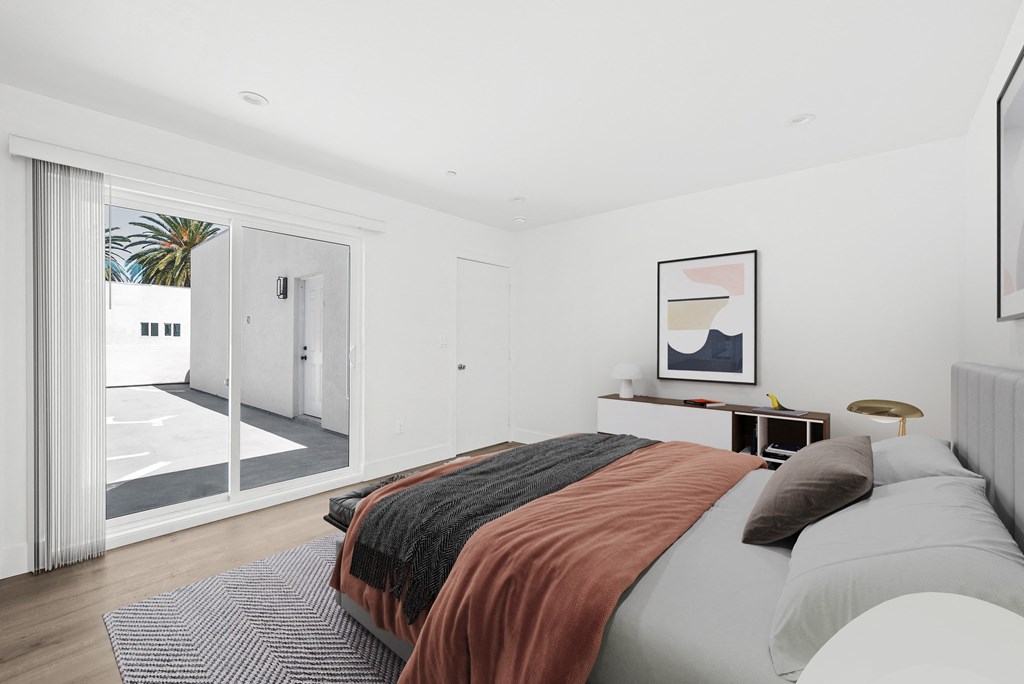 a bedroom with a bed and a sliding glass door