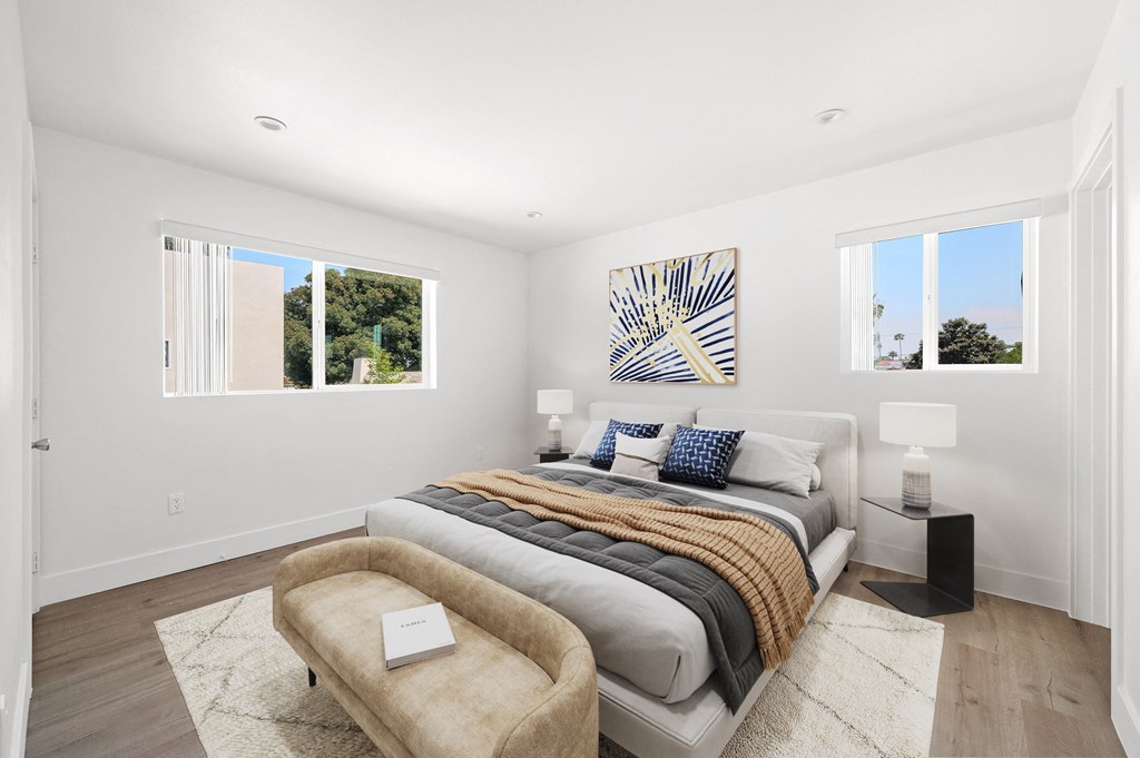 a bedroom with a bed and two windows