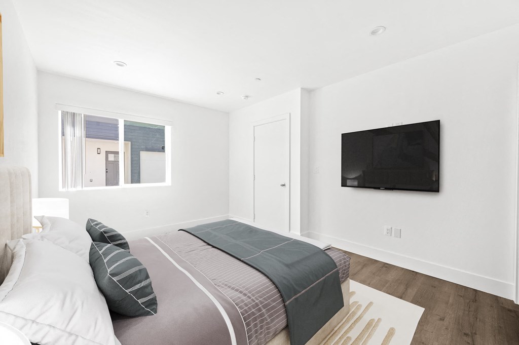 a bedroom with a bed and a tv on the wall