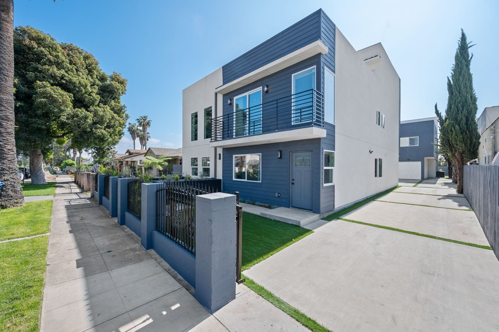a blue and white house with a sidewalk and a fence