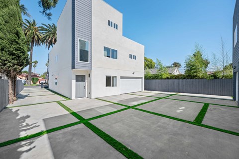 a white house with a driveway and a yard with grass