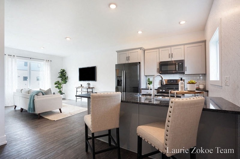 a kitchen and living room with white cabinets and a counter top