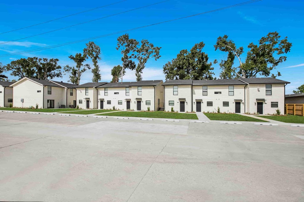 an empty parking lot in front of an apartment building