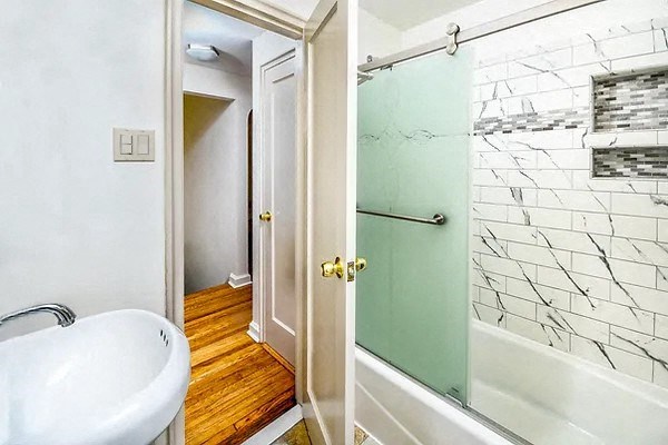 a bathroom with a tub and a shower and a sink