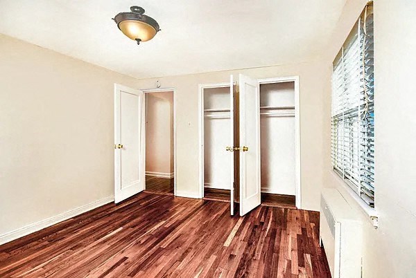 an empty room with a hard wood floor and a window