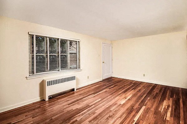 an empty room with wooden floors and a window