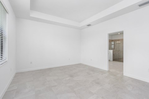 the living room of a new home with white walls and tiled flooring