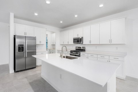 A modern kitchen with white cabinets and a large island.