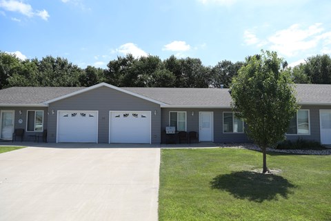 A building with a grey roof and white garage doors.