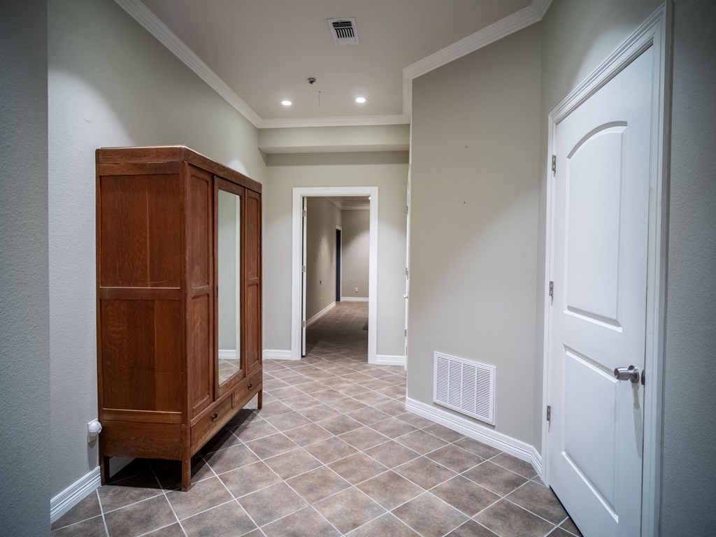 a hallway with a dresser and a door into a hallway