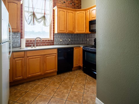 a kitchen with wooden cabinets and black appliances