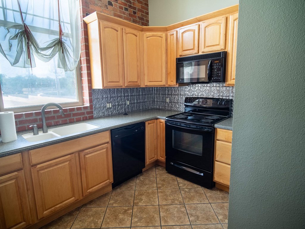 a kitchen with a stove and a sink and a window