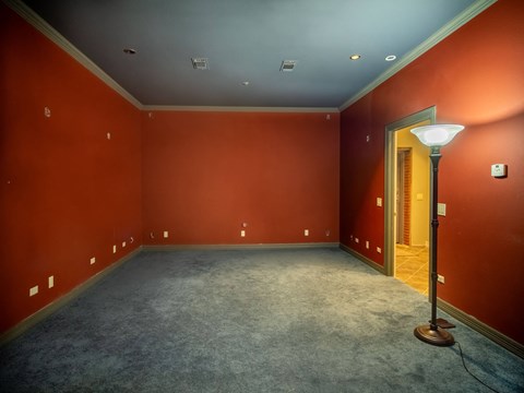 a empty room with red walls and a lamp