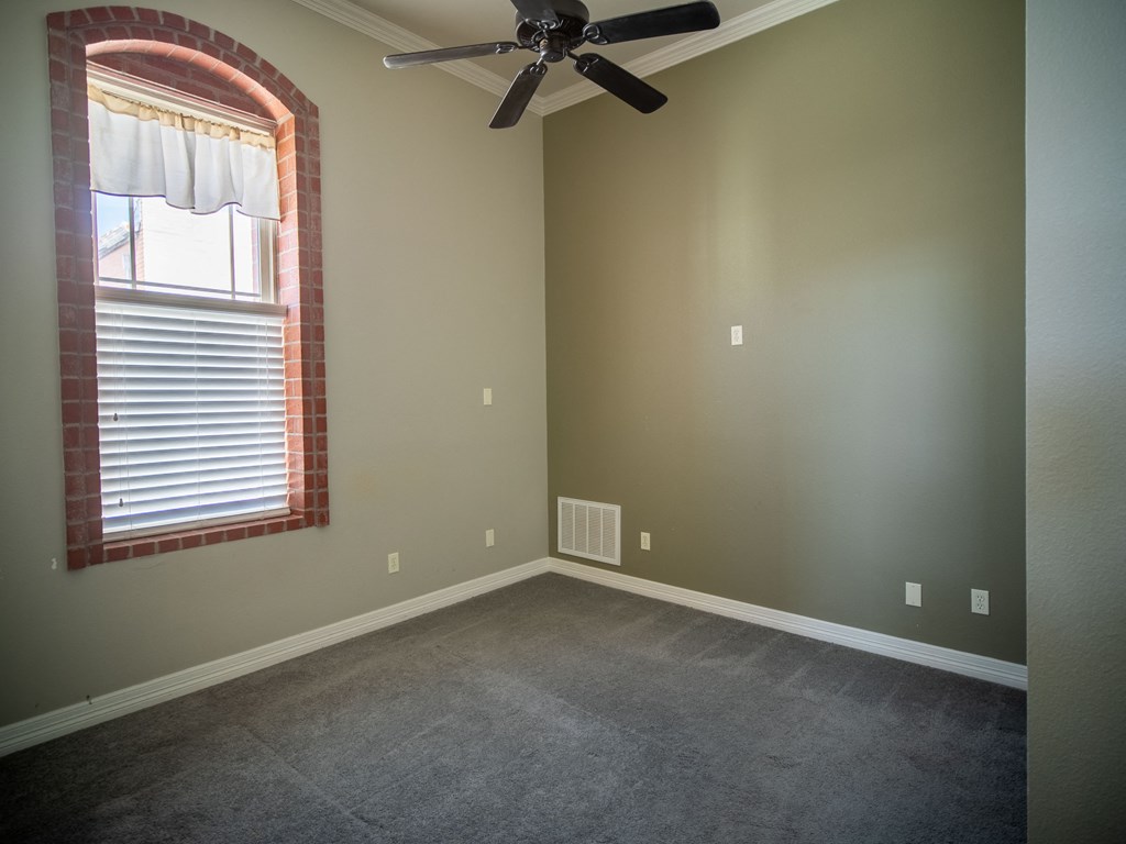 an empty room with a ceiling fan and a window