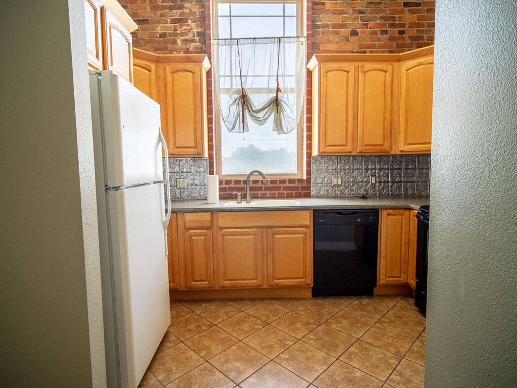 an empty kitchen with wooden cabinets and a window