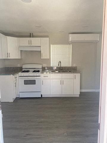 a kitchen with white cabinets and a stove and a sink