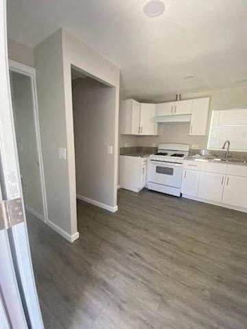 an empty kitchen with white appliances and white cabinets