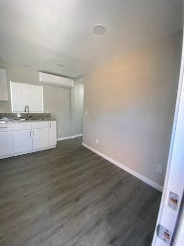 an empty living room and kitchen with a wood floor