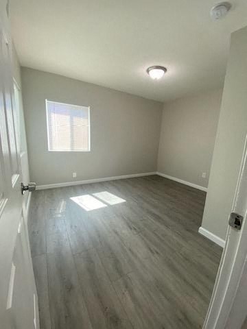 a empty room with wooden floors and a window