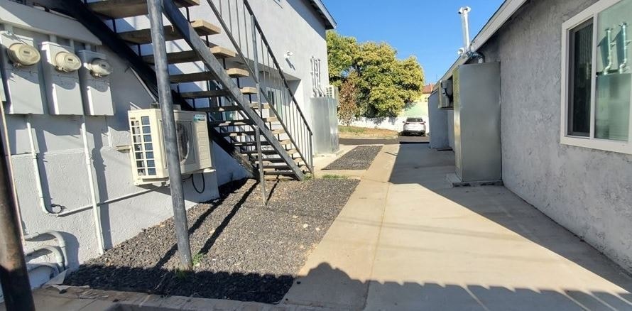 a sidewalk next to a building with a staircase