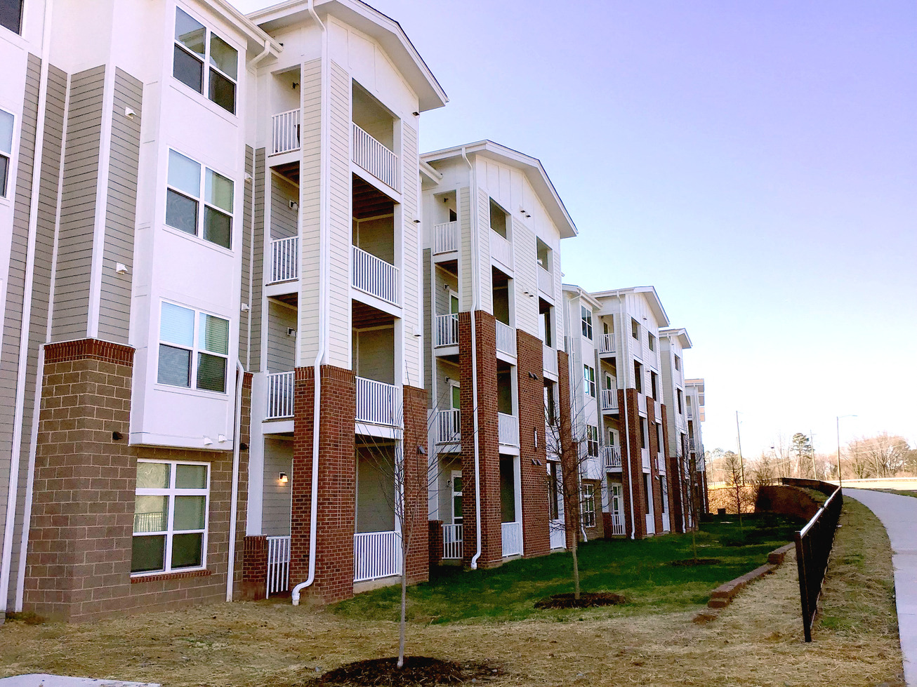 a row of apartments with balconies and grass
