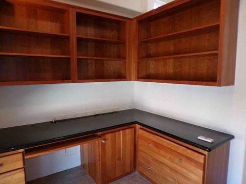 A kitchen with wooden cabinets and a black countertop.