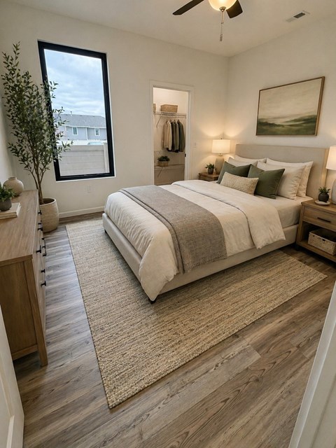 A bedroom with a large bed and a ceiling fan.