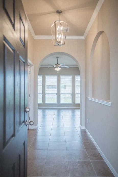 A hallway with a ceiling fan and a door on the left.
