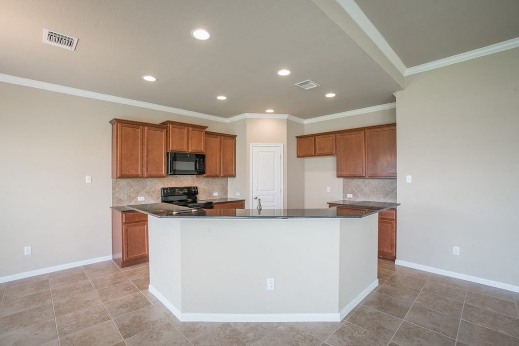 A kitchen with a white island in the middle.