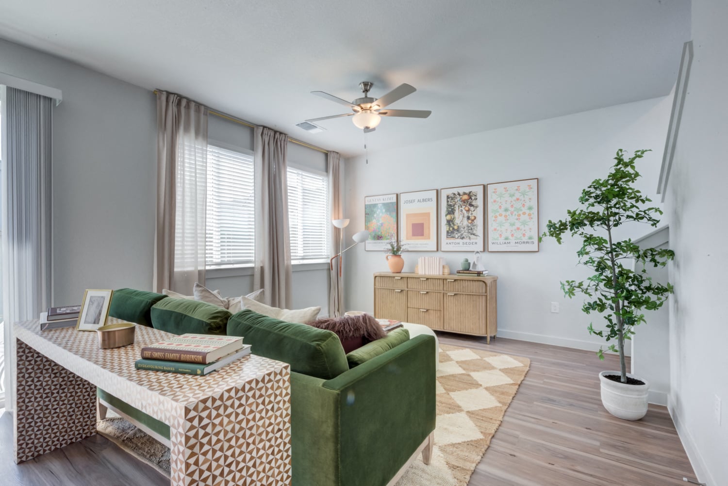 a living room with a green couch and a ceiling fan