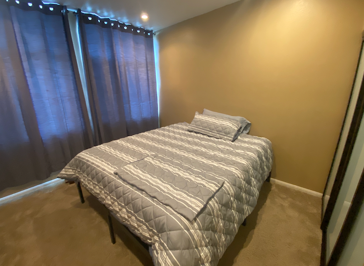 a small bedroom with a bed and a window