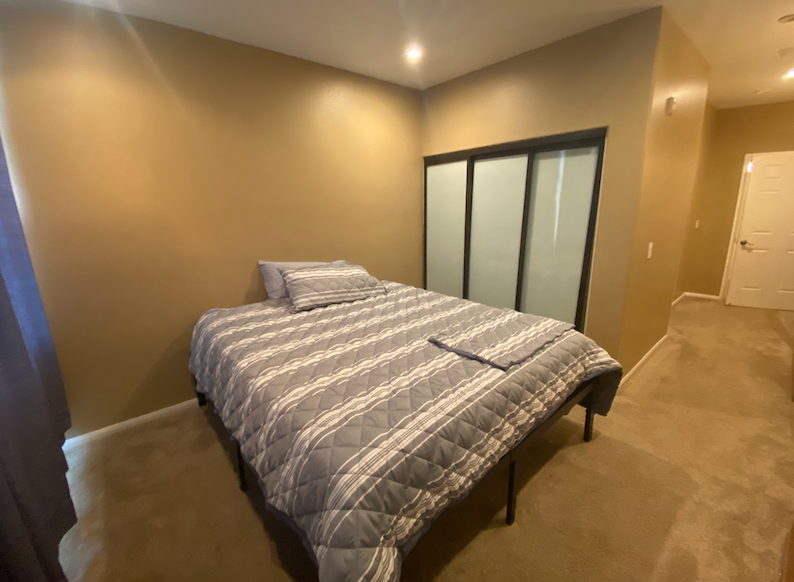 a large bedroom with a bed and a closet