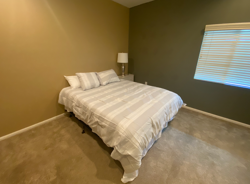 a bedroom with a bed and a large window