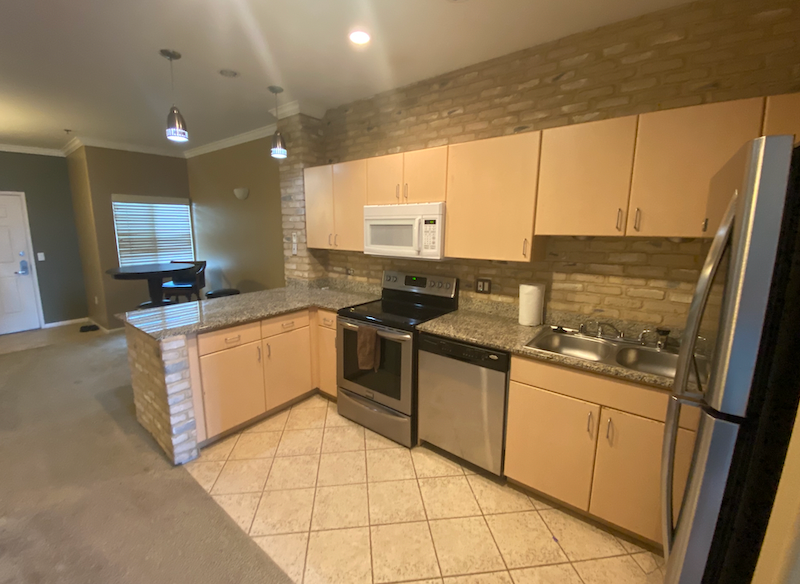an empty kitchen with granite counter tops and stainless steel appliances