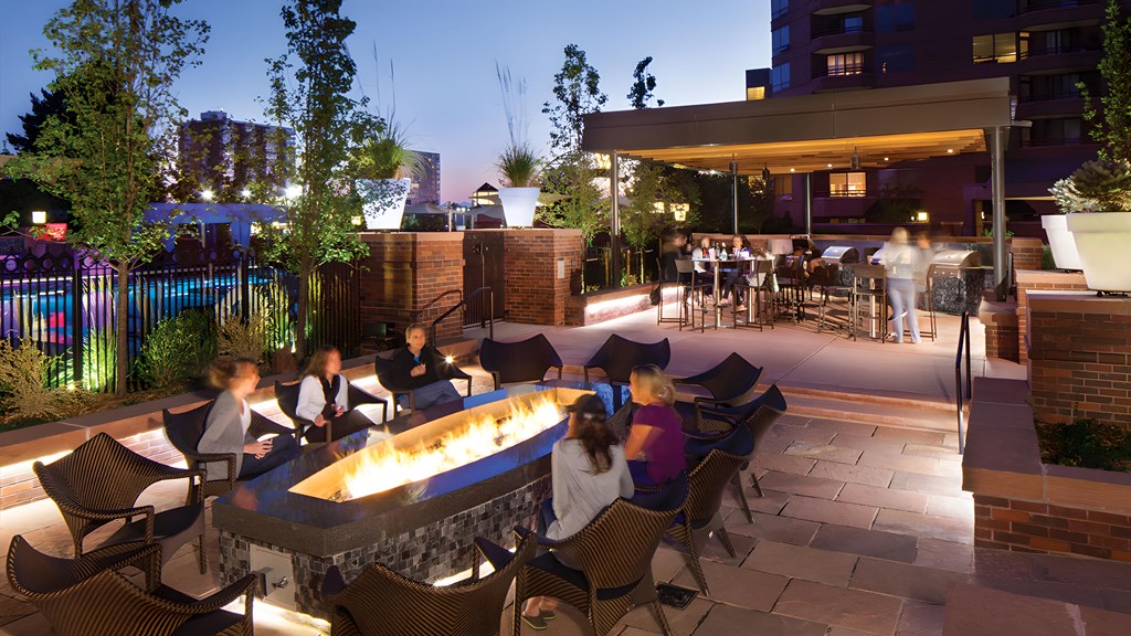 a rendering of the patio at night with people sitting around a fire pit