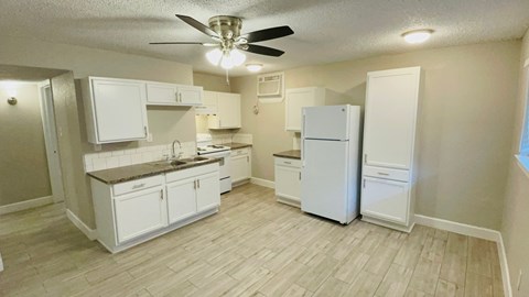 A kitchen with white appliances and cabinets.