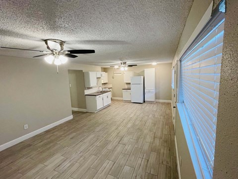 A room with a ceiling fan and wooden flooring.
