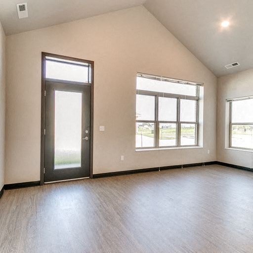 an empty living room with a door and windows
