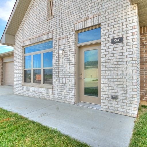 a brick building with a door and a sidewalk