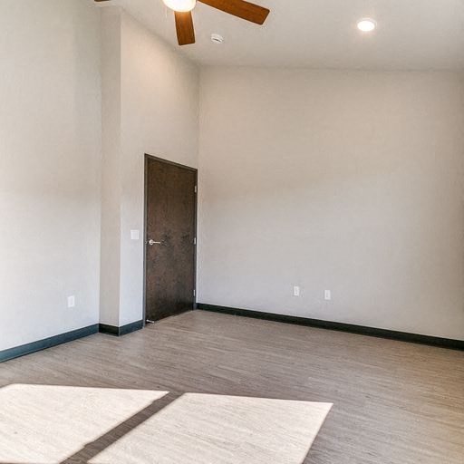 an empty room with a ceiling fan and a door