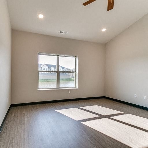 an empty living room with a window and wood floors