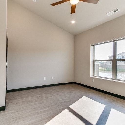 an empty living room with a ceiling fan and a large window